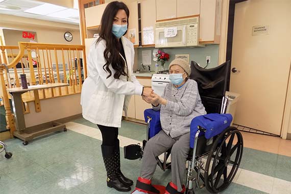 Young female doctor and wheelchair bound senior patient pose for a photo at Rego Park.