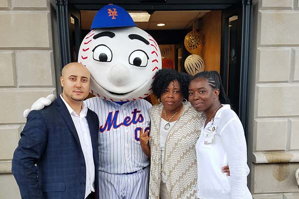 Rego Park team members posing with Mr. Met outside.